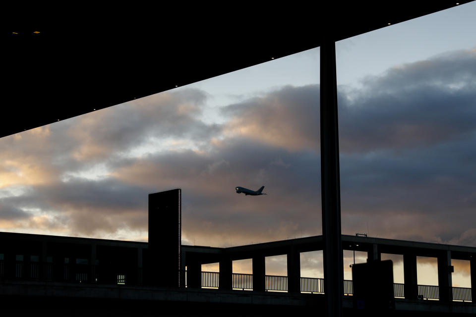 A plane departures from the airport Schoenefeld behind Terminal 1 of the new Berlin-Brandenburg-Airport 'Willy Brandt' near Berlin, in Schoenefeld, Germany, Tuesday, Oct. 27, 2020. After years of delays and massive cost overruns the opening of the German capital's new airport is scheduled for Saturday Oct. 31.(AP Photo/Markus Schreiber)