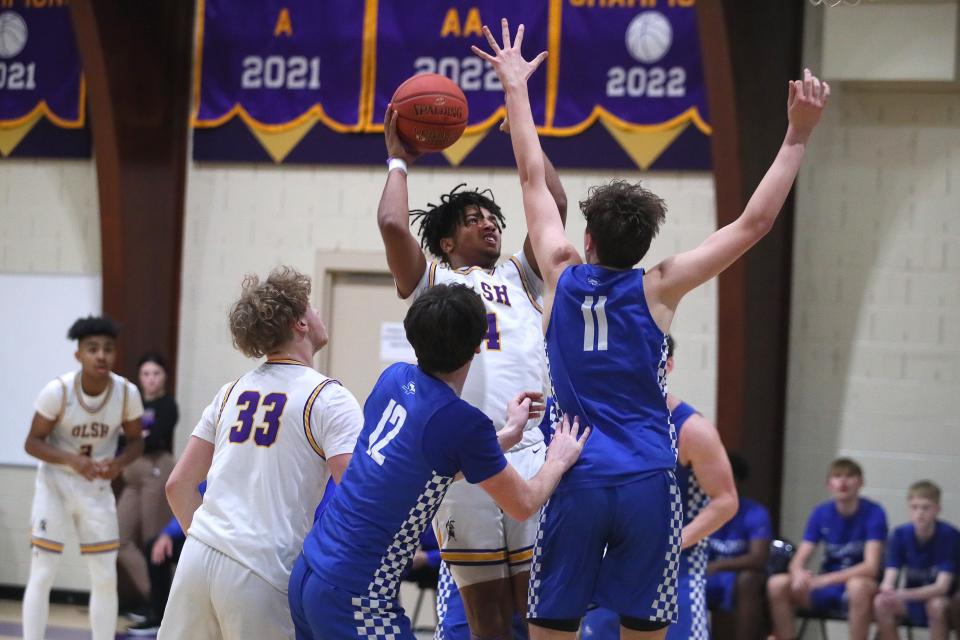 OLSH's Dereon Greer (4) attempts a layup while being heavily guarded by South Park's Luke Scarff (11) during the first half Friday night at Our Lady of the Sacred Heart High School.