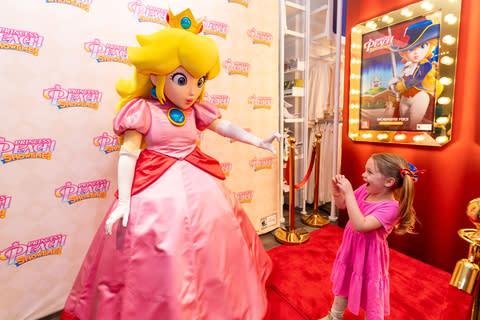 In this photo provided by Nintendo of America, June E., 4, and Princess Peach celebrate the release of Princess Peach: Showtime. You can purchase the game at the Nintendo New York Store in Rockefeller Center.  This weekend event, featuring gameplay and theatrical photo ops on the Nintendo Switch system, will run until March 24th.