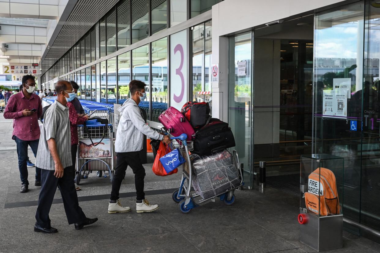 A traveller pushes his luggages on a trolley as he enters the departure hall at Changi International Airport in Singapore on August 19, 2021. (Photo by Roslan RAHMAN / AFP) (Photo by ROSLAN RAHMAN/AFP via Getty Images)