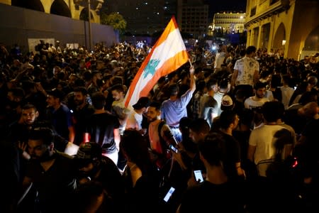 A demonstrator holds a Lebanese flag during a protest over deteriorating economic situation in Beirut