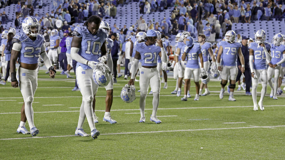 Dejected North Carolina players walk off the field after an upset loss to Virginia at the end of an NCAA college football game, Saturday, Oct. 21, 2023, in Chapel Hill, N.C. (AP Photo/Chris Seward)