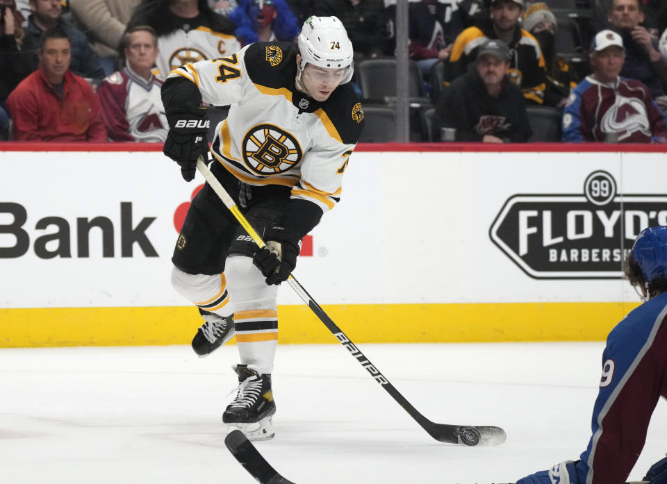 Boston Bruins left wing Jake DeBrusk, left, shoots the puck for a goal past Colorado Avalanche defenseman Samuel Girard in the second period of an NHL hockey game Wednesday, Jan. 26, 2022, in Denver. (AP Photo/David Zalubowski)