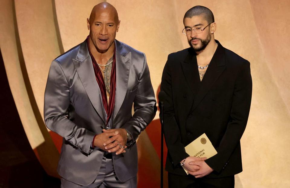 <p>Kevin Winter/Getty</p>  Dwayne "The Rock" Johnson and Bad Bunny speak onstage during the 96th annual Academy Awards.