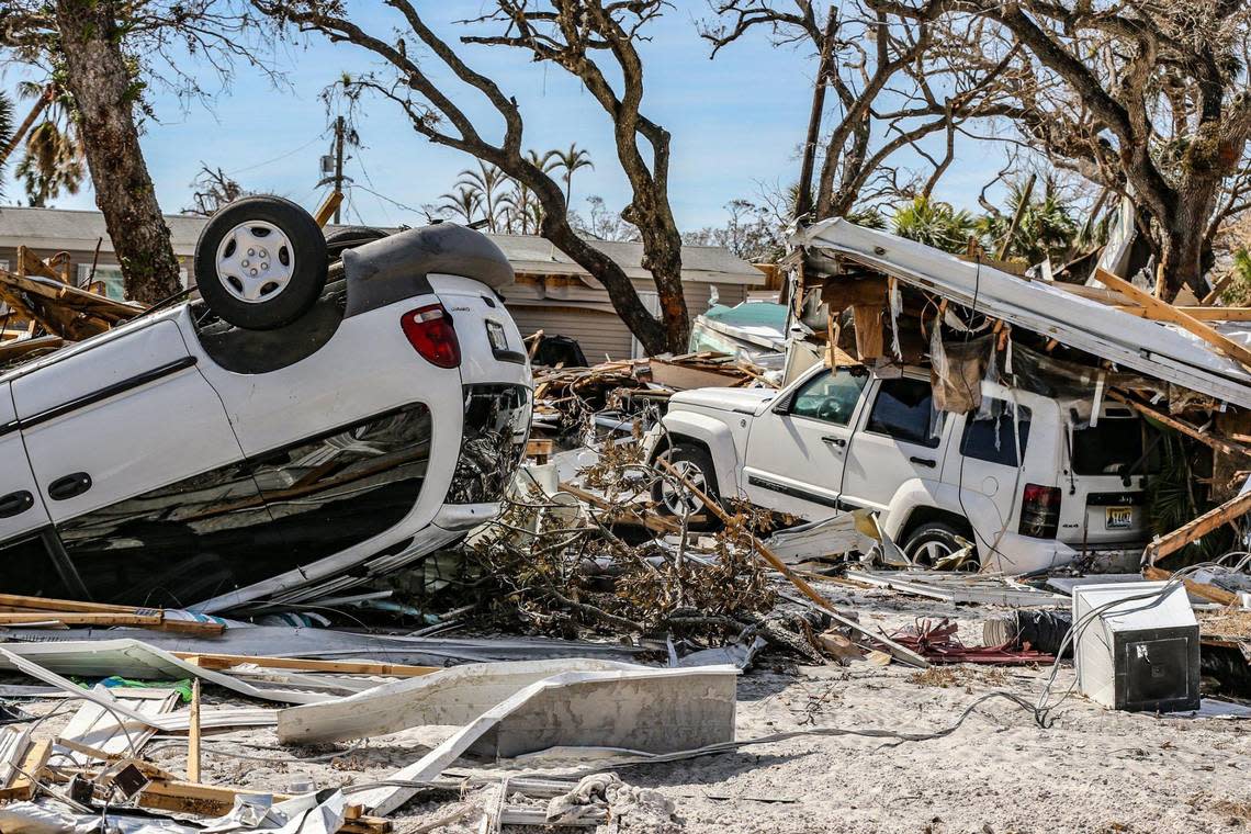 Damaged cars lay among the debris of homes destroyed by Hurricane Ian on Fort Myers Beach on Monday, Oct. 3, 2022. Al Diaz/adiaz@miamiherald.com