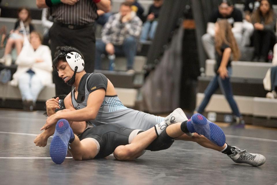 Pueblo West's Eleazar Bachicha works to roll Pueblo South's David Carillo during their 106-pound match on Wednesday, January 24, 2024.