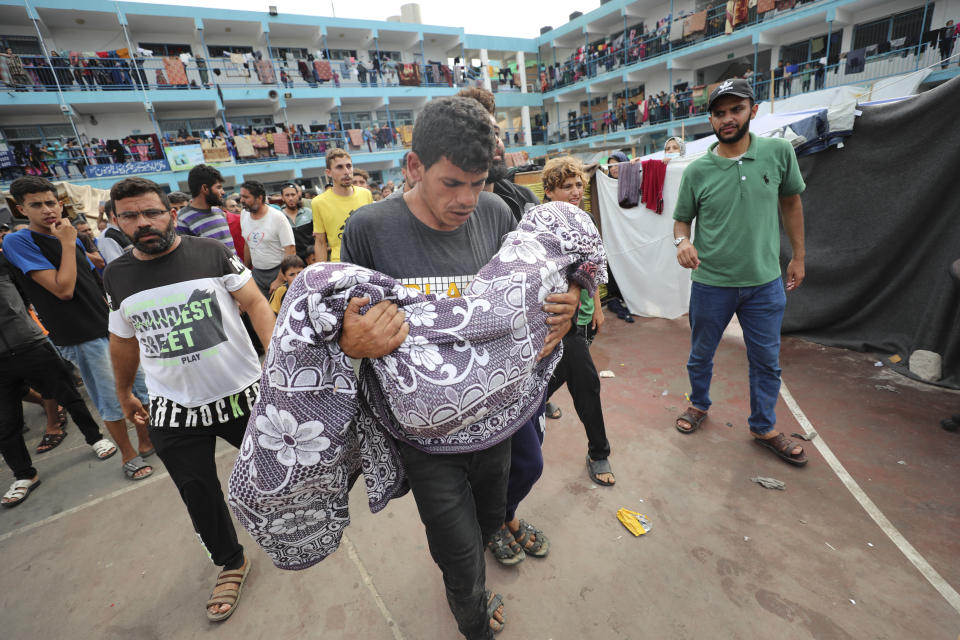 Palestinians carry a child killed in the Israeli bombardment of the Gaza Strip during his funeral at a UN-run school in Deir al Balah, Gaza Strip, Friday, Oct. 27, 2023. (AP Photo/Ali Mahmoud)