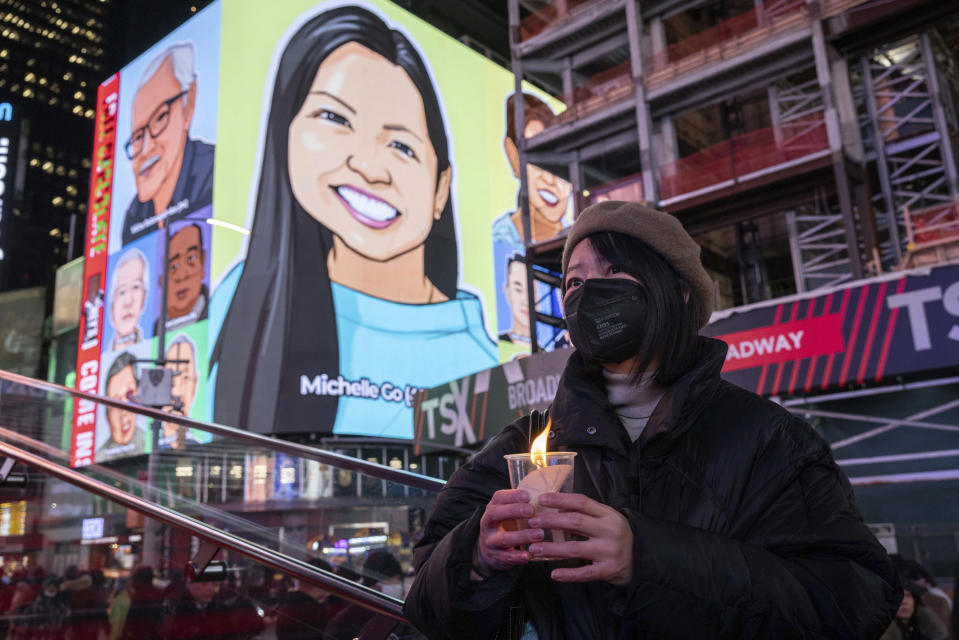 FILE - A person holds a candle during a vigil, Jan. 18, 2022, in New York's Times Square, in honor of Michelle Alyssa Go, a victim of a subway attack several days earlier. Three random killings: a woman pushed in front of a train, another punched at a bus stop and a third stabbed to death while working alone in a store, and three homeless men charged with the crimes have reignited anger and frustration with the intractable issue of homelessness in New York and Los Angeles. (AP Photo/Yuki Iwamura, File)