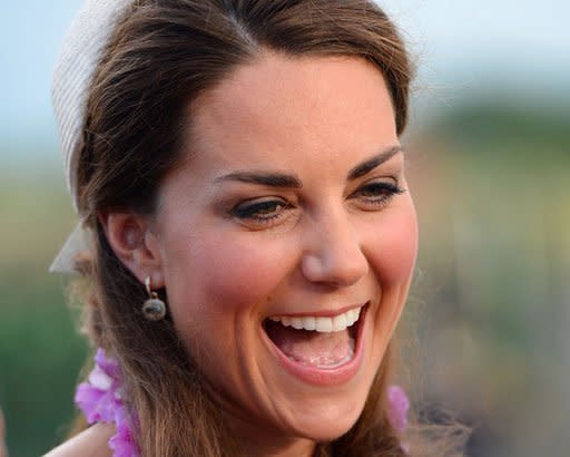 Catherine, the Duchess of Cambridge, laughs as she and her husband Britain's Prince William speak to dignitaries upon their arrival in Honiara on September 16. Britain's Prince William and wife Catherine were greeted by huge crowds as they landed in the lush, steamy Solomon Islands on Sunday, while a row raged in Europe about topless photos of the Duchess