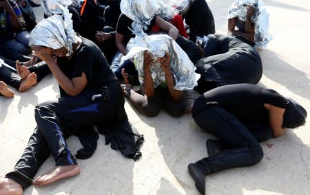 Migrants sit at a naval base after being rescued by Libyan coast guards in Tripoli, Libya June 18, 2018. Picture taken June 18, 2018.  REUTERS/Ismail Zitouny