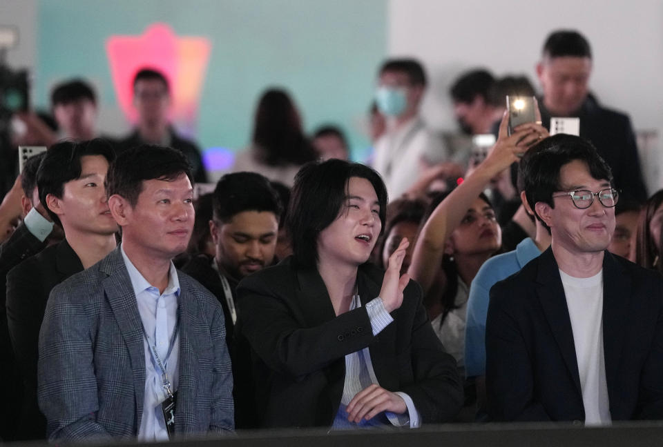 SUGA, center, a member of South Korean K-pop band BTS, waves during the Galaxy Unpacked 2023 event at the COEX in Seoul, South Korea, Wednesday, July 26, 2023. Samsung Electronics on Wednesday unveiled two foldable smartphones as it continues to bet on devices with bending screens, a budding market that has yet to fully take off because of high prices. (AP Photo/Ahn Young-joon)