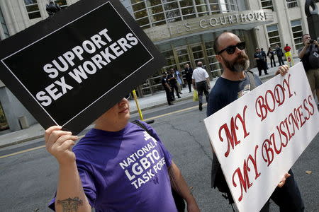 Demonstrators hold signs as they protest the arrests of male escort service Rentboy.com staffers outside United States Court in the Brooklyn borough of New York City, September 3, 2015. REUTERS/Mike Segar