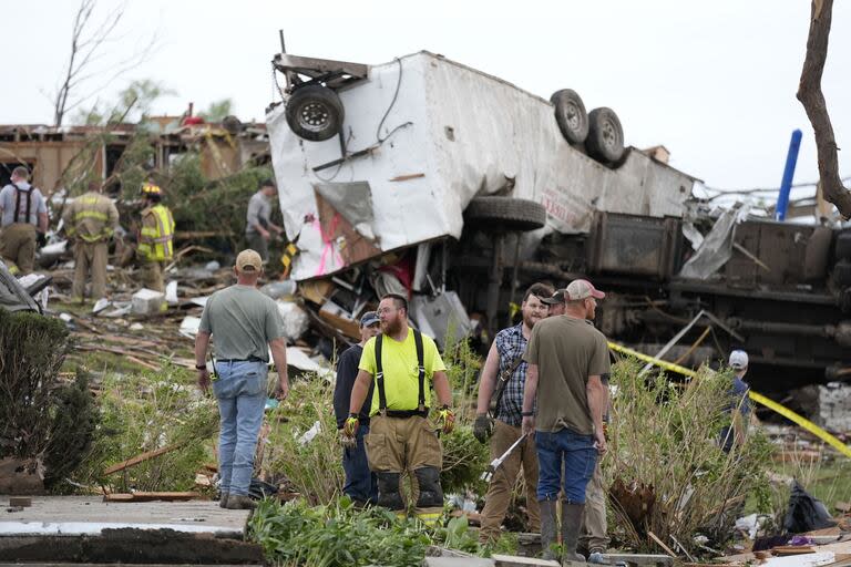 Trabajadores buscan entre los restos de una propiedad dañada por un tornado