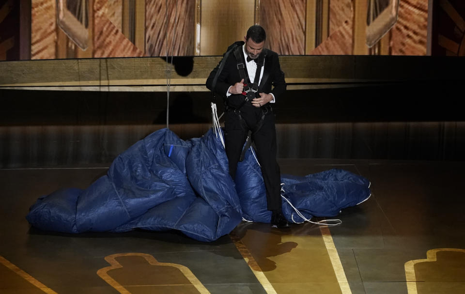 Host Jimmy Kimmel drops onto stage by parachute at the Oscars on Sunday, March 12, 2023, at the Dolby Theatre in Los Angeles. (AP Photo/Chris Pizzello)