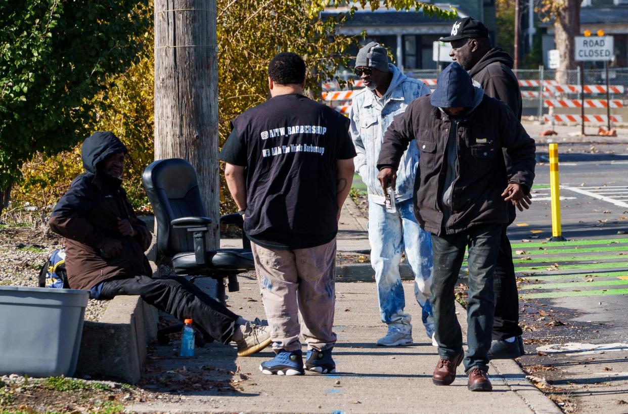 Between cuts Marvin Taylor, owner of All in the Wrists Barbershop, talks with a group of men gathered Thursday, Nov. 9, 2023, near his shop that sits on 22nd between Meridian and Illinois Streets, north of downtown Indianapolis.