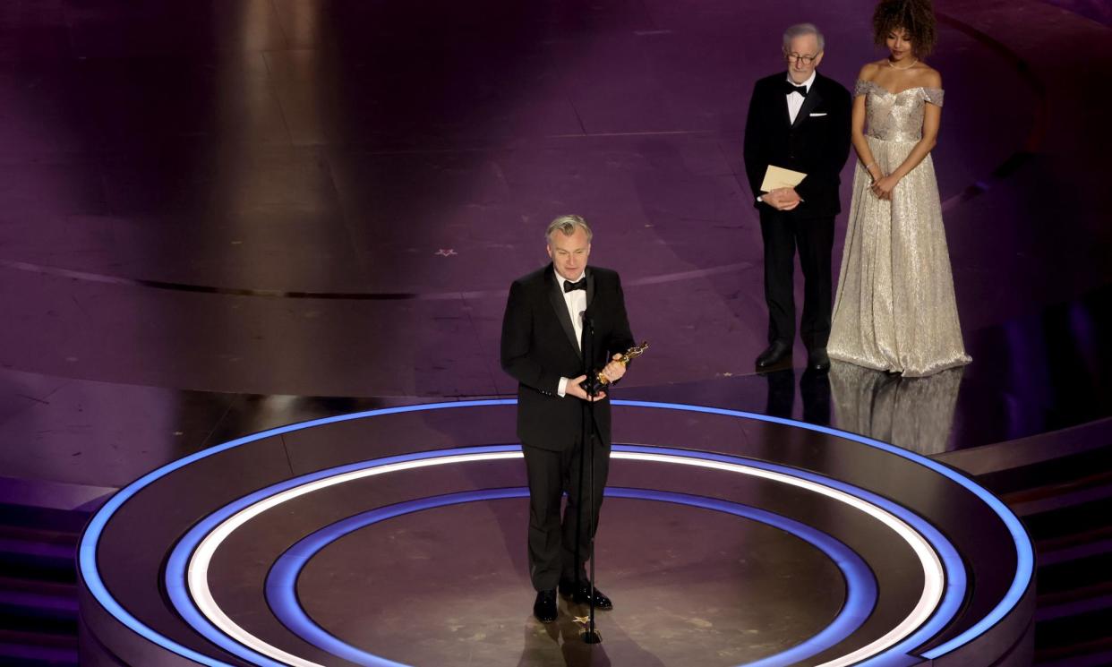 <span>Christopher Nolan accepts the Best Directing Oscar for Oppenheimer, as Steven Spielberg, who presented the award, looks on.</span><span>Photograph: Kevin Winter/Getty Images</span>