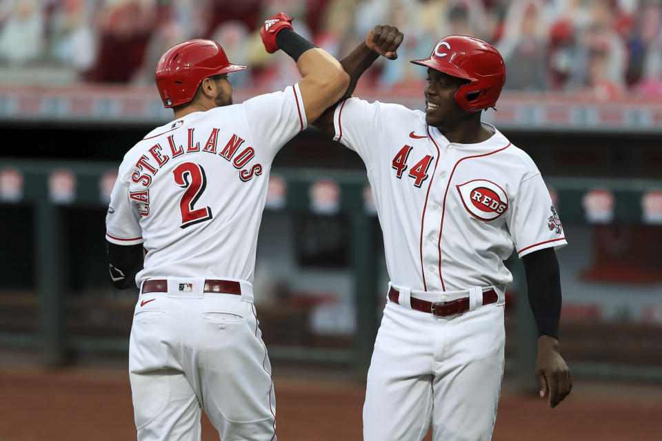 Cincinnati Reds' Nick Castellanos, left. celebrates hitting a two-run home run with teammate Aristides Aquino, right, in the first inning during a baseball game against the Milwaukee Brewers in Cincinnati, Tuesday, Sept. 22, 2020. (AP Photo/Aaron Doster)