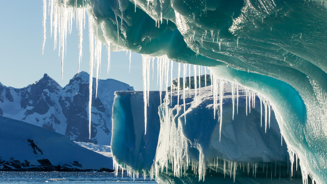  Antarctica, Petermann Island, Icicles hang from melting iceberg near Lemaire Channel. 