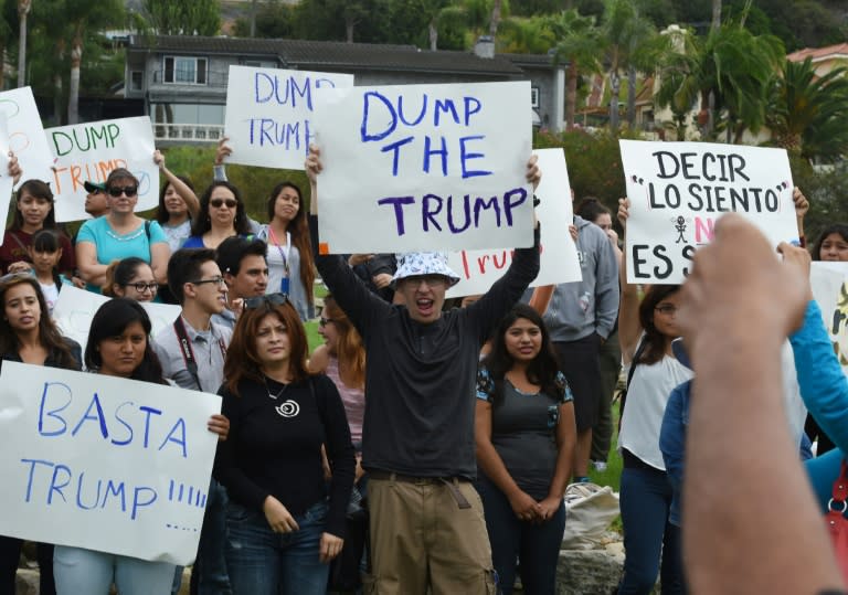 People march during a protest rally denouncing alleged racist remarks by Republican presidential candidate Donald Trump, at the Trump National Golf Club in Palos Verdes, California on October 17, 2015