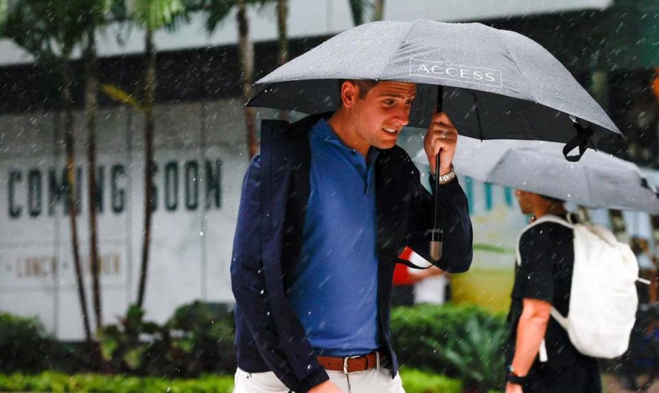 Pedestrians brace against the rain and wind with umbrellas in hand as they cross the street at Brickell City Center in Miami, Florida, on Tuesday, September 27, 2022. All of South Florida is now in alert for Hurricane Ian’s tropical storm-force winds.