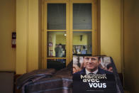 FILE - A campaign poster reading "Emmanuel Macron with you" is displayed during a local meeting for the upcoming parliamentary elections, in Lyon, central France, Tuesday, June 7, 2022. French voters were choosing lawmakers in a parliamentary election Sunday, June 12, 2022 as President Emmanuel Macron seeks to secure his majority while under growing threat from a leftist coalition. (AP Photo/Laurent Cipriani, File)