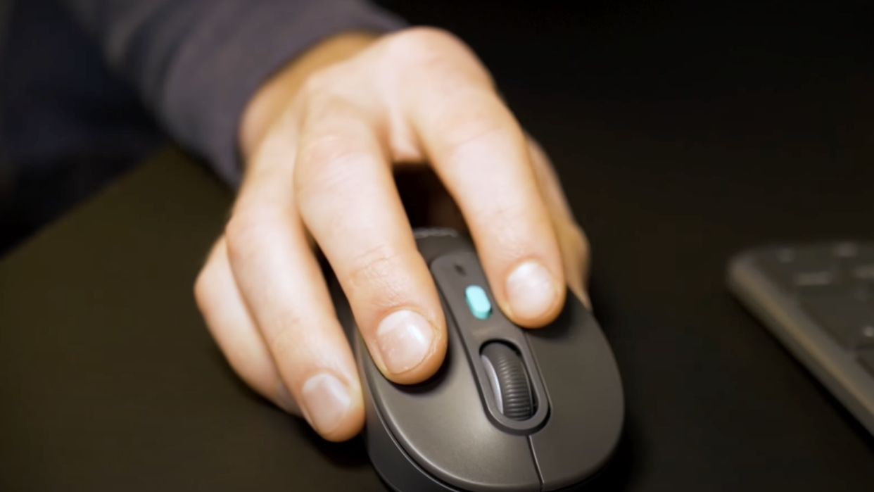  A hand using a Logitech mouse. 