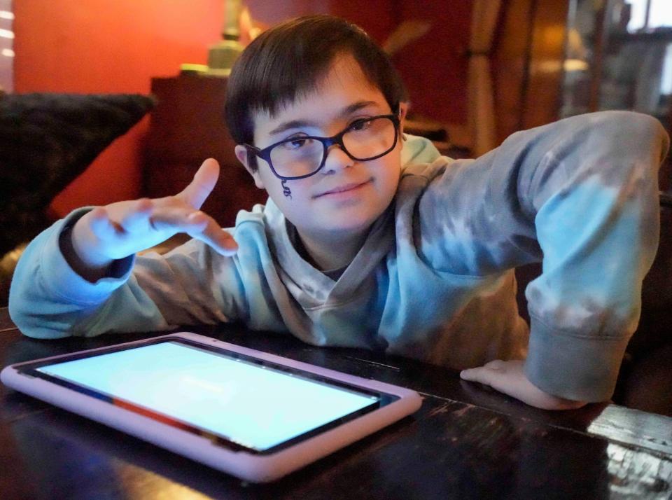 Henry Wisniewski, 11, plays with his Imaginext action figures while watching YouTube videos. Henry, who has Down syndrome, uses digital technology to help him improve his conversational skills.