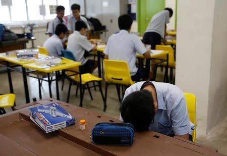 A student takes a break during a model aeroplane assembly enrichment class at a secondary school in Singapore October 27, 2016. REUTERS/Edgar Su/Files