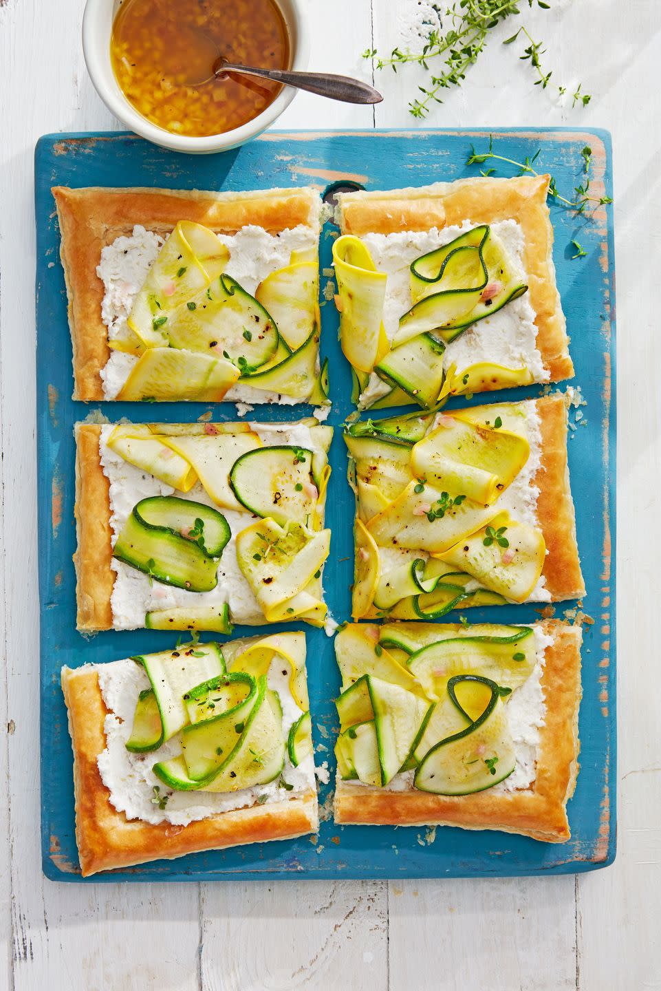 marinated squash tart on a blue serving board and cut into squares