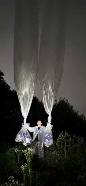 PHOTO: Leader of human rights NGO Park Sang Has holds balloons up in the sky, aiming to fly them at the North Korean border, June 28, 2022. (Fighters For North Korea)