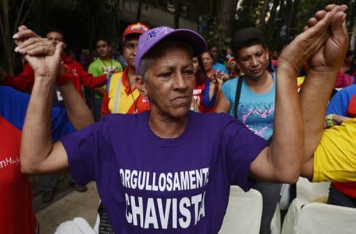 Entre rezos y cánticos, cientos de seguidores y colaboradores del presidente venezolano, Hugo Chávez, celebraron este martes por la noche el éxito de la operación contra el cáncer a la que se sometió el mandatario en Cuba. (AFP | juan barreto)