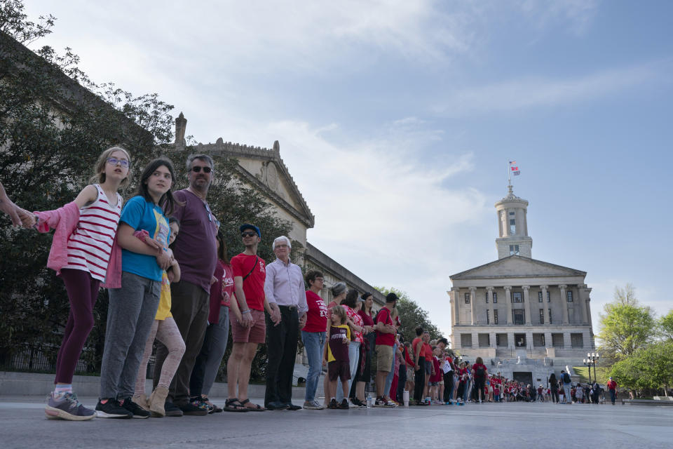 Demonstrators hold hands and lock arms with each other during the "Arms Are for Hugging" protest for gun control legislation, Tuesday, April 18, 2023, in Nashville, Tenn. Participants created a human chain starting from Monroe Carell Jr. Children's Hospital at Vanderbilt, where victims of The Covenant School shooting were taken on March 27, and ending at the Tennessee State Capitol. (AP Photo/George Walker IV)