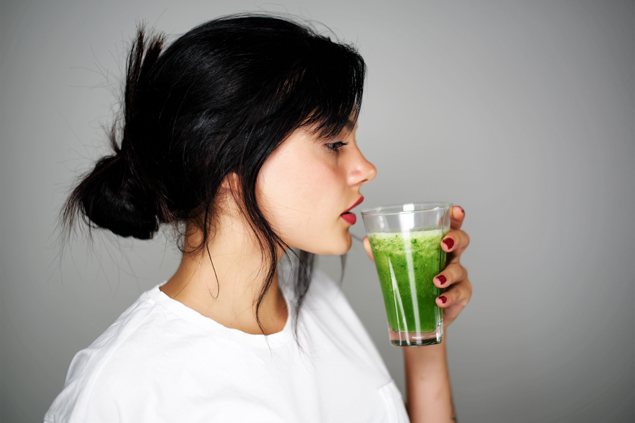 woman drinking green juice