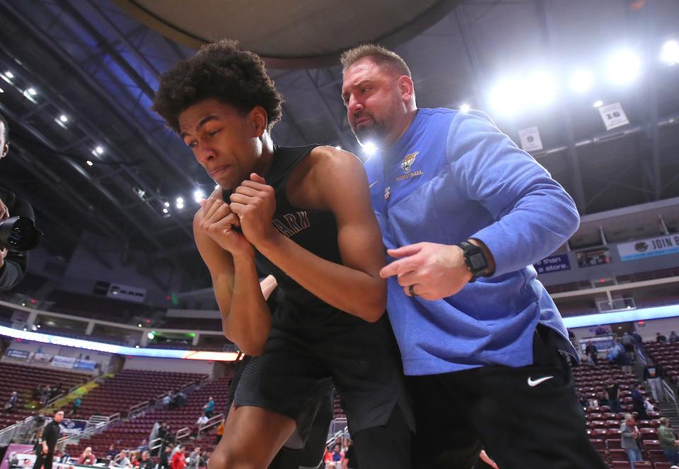 Lincoln Park assistant coach Ryan Noahe (right) celebrates the win with an emotional Brandin Cummings (left) after the Leopards defeated Neumann Goretti 62-58 in the PIAA 4A Championship game Thursday night at the Giant Center in Hershey, PA. 