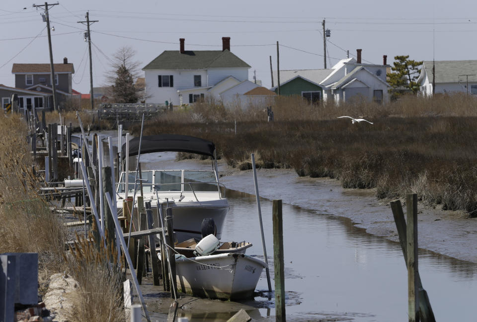 FIL - This Wednesday April 3, 2013 file photo shows a creek along with boats on Tangier Island, Va. The fishing community in the middle of the Chesapeake Bay has reported zero cases of the coronavirus. But the virus would be devastating if it were to reach the island, which has a large elderly population and no full-time doctor. (AP Photo/Steve Helber)