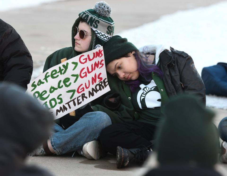 Lansing Community College students Milo Smith, left, and Alec Xavier-Aviles braved the 22-degree cold to demonstrate Feb. 17, 2023,  at the 'End Gun Violence - Spartan Strong' rally at the state Capitol in Lansing. The event was organized by MSU students sparked by Monday’s shooting rampage on the campus of Michigan State University where three died and four were critically injured. About fifty attended the event.