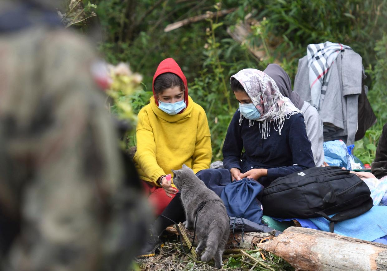 Migrants wait in an area between the borders of Belarus and Poland near the village of Usnarz Gorny in Poland, on Aug. 20, 2021. A refugee rights group in Poland said that dozens of people who fled Afghanistan were trapped for 12 days in an area between the borders, caught up in a standoff between the two countries.