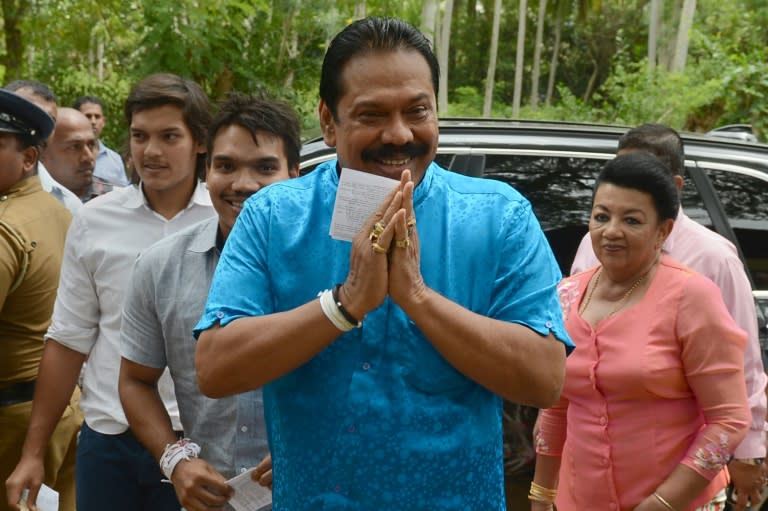 Former Sri Lankan president and parliamentary candidate Mahinda Rajapakse arrives with his family to cast his vote at a polling station in his native town of Tangalla on August 17, 2015