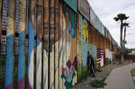 A man looks through the first wall at Friendship Park, near where the border separating Tijuana, Mexico, and San Diego meets the Pacific Ocean Tuesday, Jan. 19, 2021, in Tijuana, Mexico. In the days before Joe Biden became president, construction crews worked quickly to finish Donald Trump's wall at an iconic cross-border park overlooking the Pacific Ocean that then-first lady Pat Nixon inaugurated in 1971 as symbol of international friendship. (AP Photo/Gregory Bull)