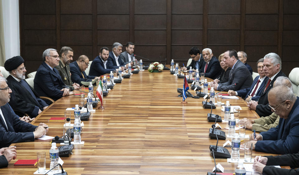 Cuban President Miguel Diaz Canel, right, sits across the table from Iran's President Ebrahim Raisi, alongside their their delegations at Revolution Palace in Havana, Cuba, Thursday, June 15, 2023. (Yamil Lage/Pool photo via AP)