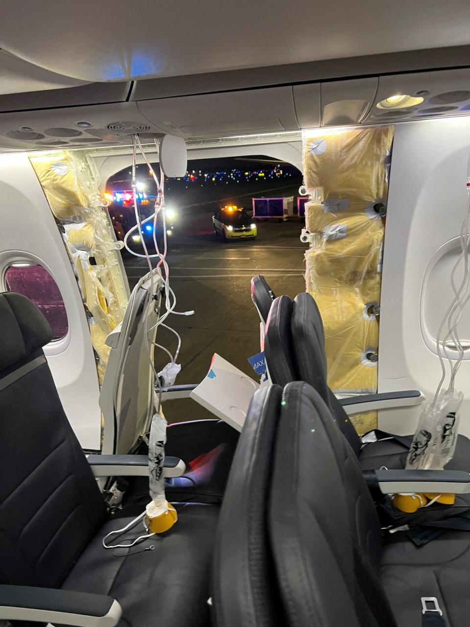 Passenger oxygen masks hang from the roof next to a missing window and a portion of a side wall of an Alaska Airlines Flight 1282 (Instagram/@strawberrvy via REUTE / Reuters)