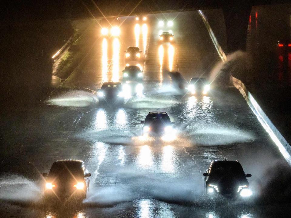 cars drive through flooded water on san francisco interstate at night