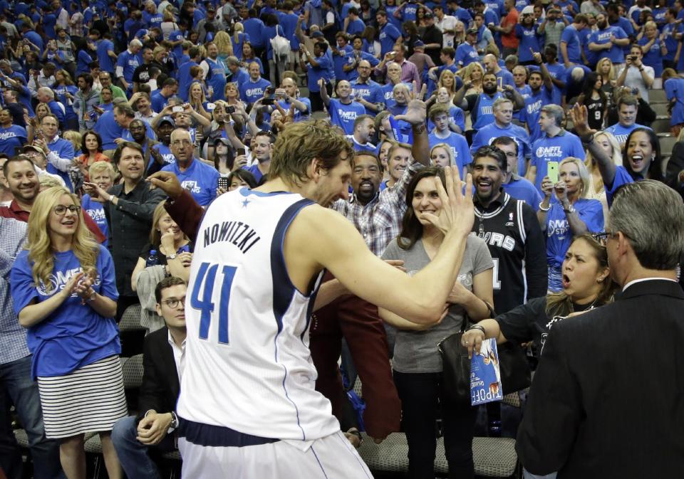 Dallas Mavericks' Dirk Nowitzki (41), of Germany, celebrates with fans after a 113-111 win over the San Antonio Spurs in an NBA basketball first-round playoff series on Friday, May 2, 2014, in Dallas. (AP Photo/Tony Gutierrez)