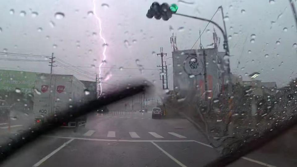 滂沱大雨中突然出現一道紫色雷電，貫穿了天空。（圖／翻攝自台南大小事）