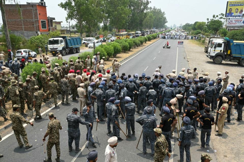 Anti riot police stand guard as farmers march to protest against India’s Prime Minister and leader of the ruling Bharatiya Janata Party (BJP) Narendra Modi, to demand minimum crop prices on the outskirts of Gurdaspur (AFP via Getty Images)