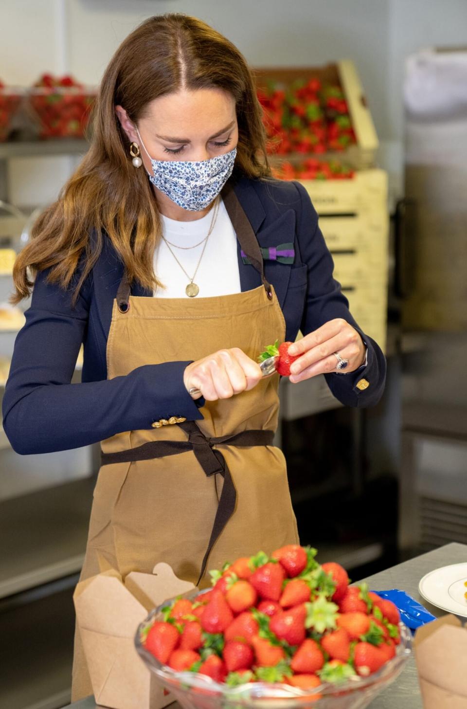 HRH Catherine, The Duchess of Cambridge, Patron of the All England Lawn Tennis Club, tries her hand at preparing some of the world famous Wimbledon strawberries