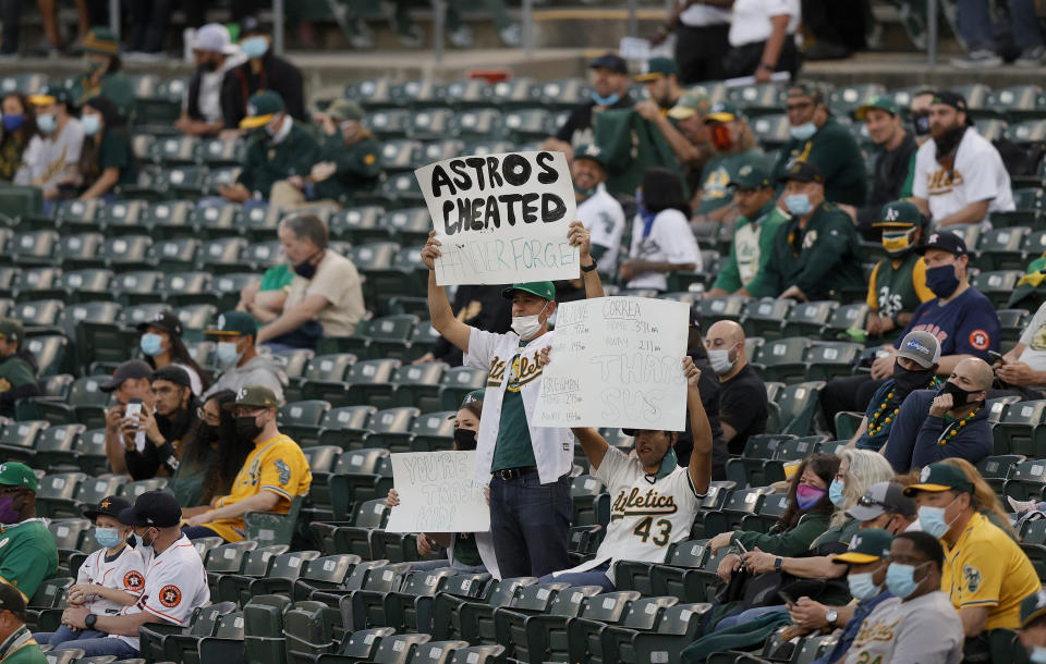 OAKLAND, CALIFORNIA - APRIL 01: Oakland Athletics fans hold up signs about the Houston Astros cheating during their Opening Day game at RingCentral Coliseum on April 01, 2021 in Oakland, California. (Photo by Ezra Shaw/Getty Images)