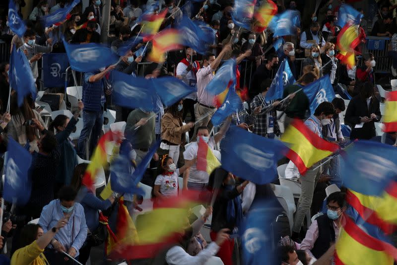 Simpatizantes de la dirigente de la Comunidad de Madrid y candidata del Partido Popular (PP), Isabel Díaz Ayuso, esperan frente a la sede del PP el anuncio de los resultados de las elecciones regionales, en Madrid