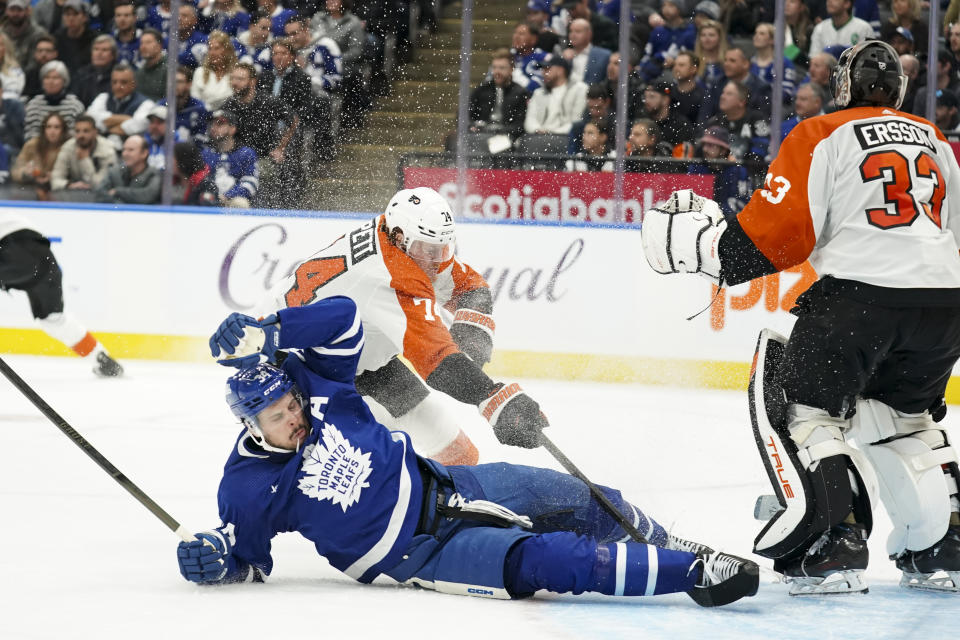 Toronto Maple Leafs center Auston Matthews (34) falls while being chased by Philadelphia Flyers right wing Owen Tippett (74) during the second period of an NHL hockey game Thursday, Feb. 15, 2024, in Toronto. (Arlyn McAdorey/The Canadian Press via AP)