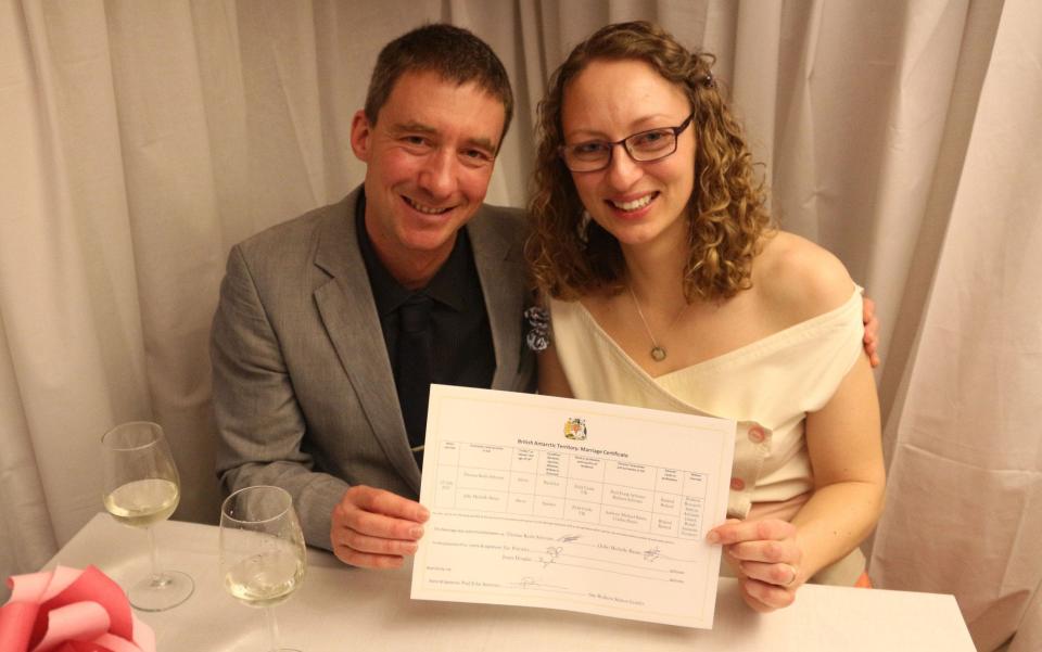 Julie Baum and Tom Sylvester hold their marriage certificate - Credit: British Antarctic Survey/PA